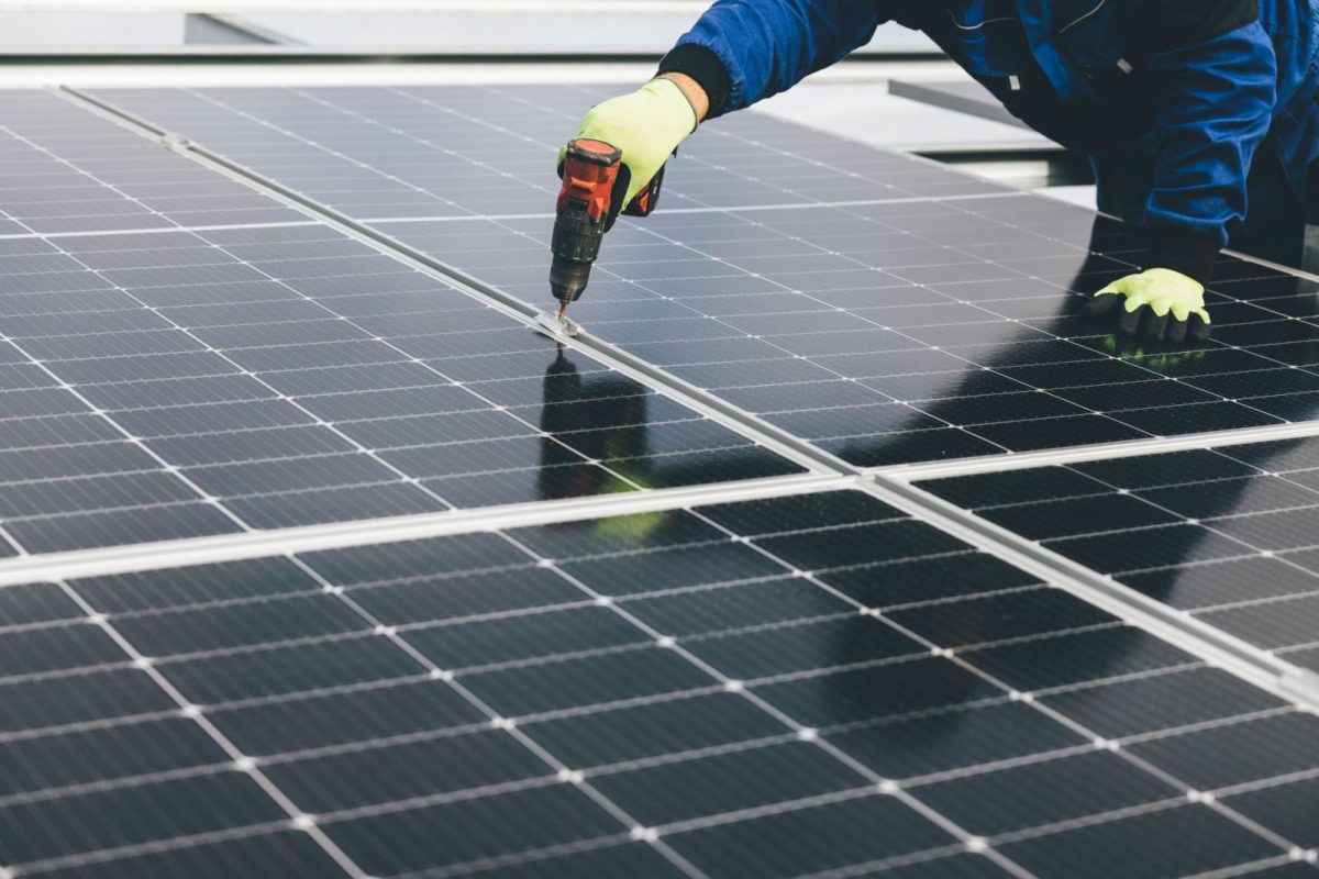 Installer mounting solar panels on a home rooftop
