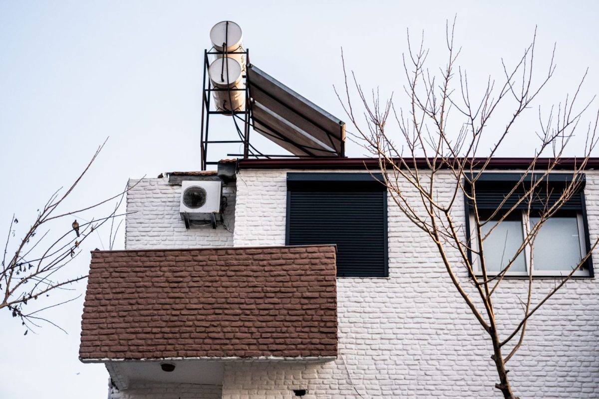 String inverter mounted on an exterior wall next to a meter