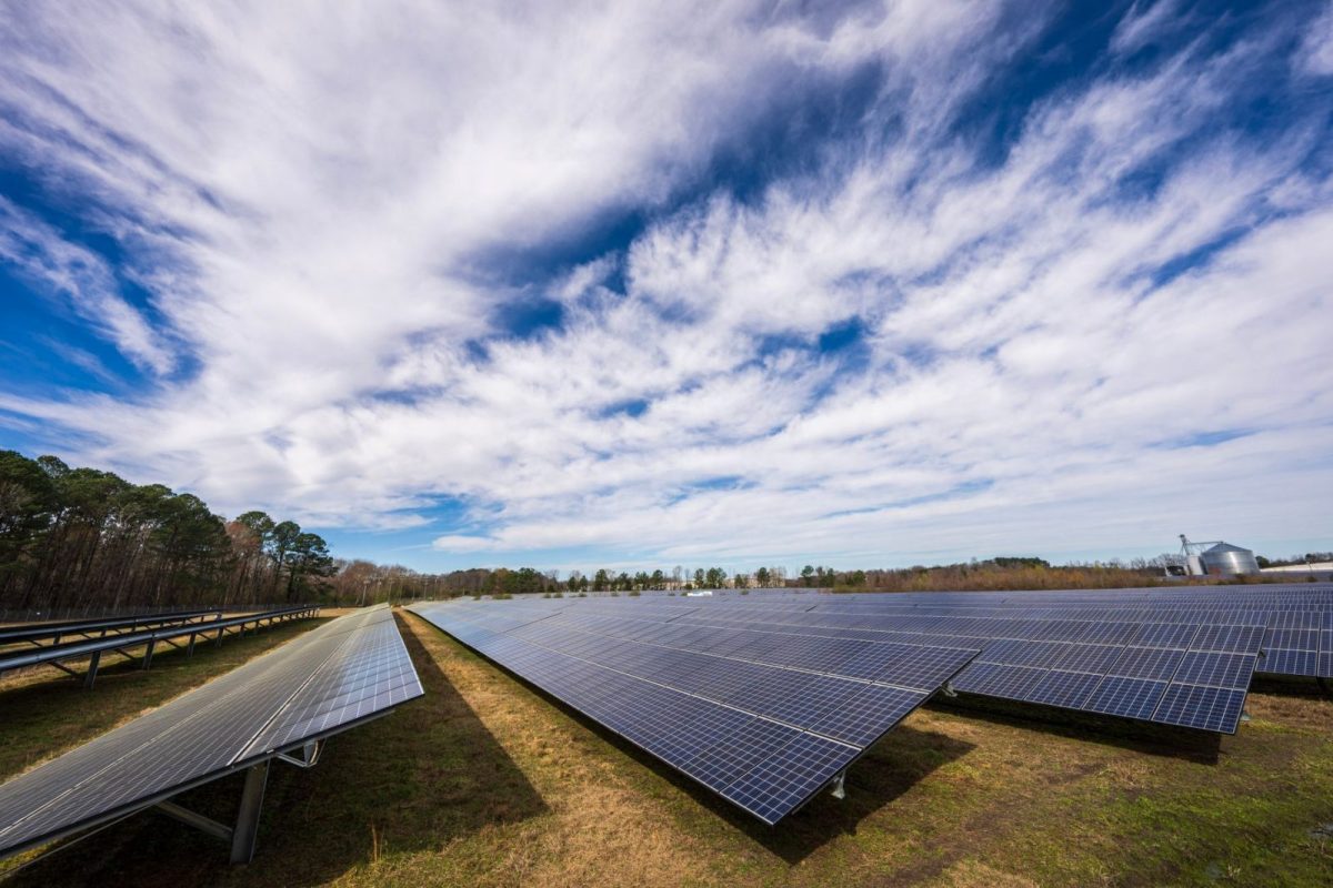 Rooftop solar panels under a clear sky feeding a home battery bank
