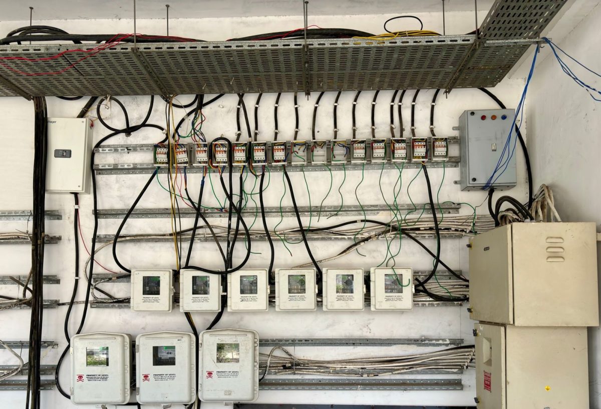 Microinverter mounted under a solar panel on a rooftop array