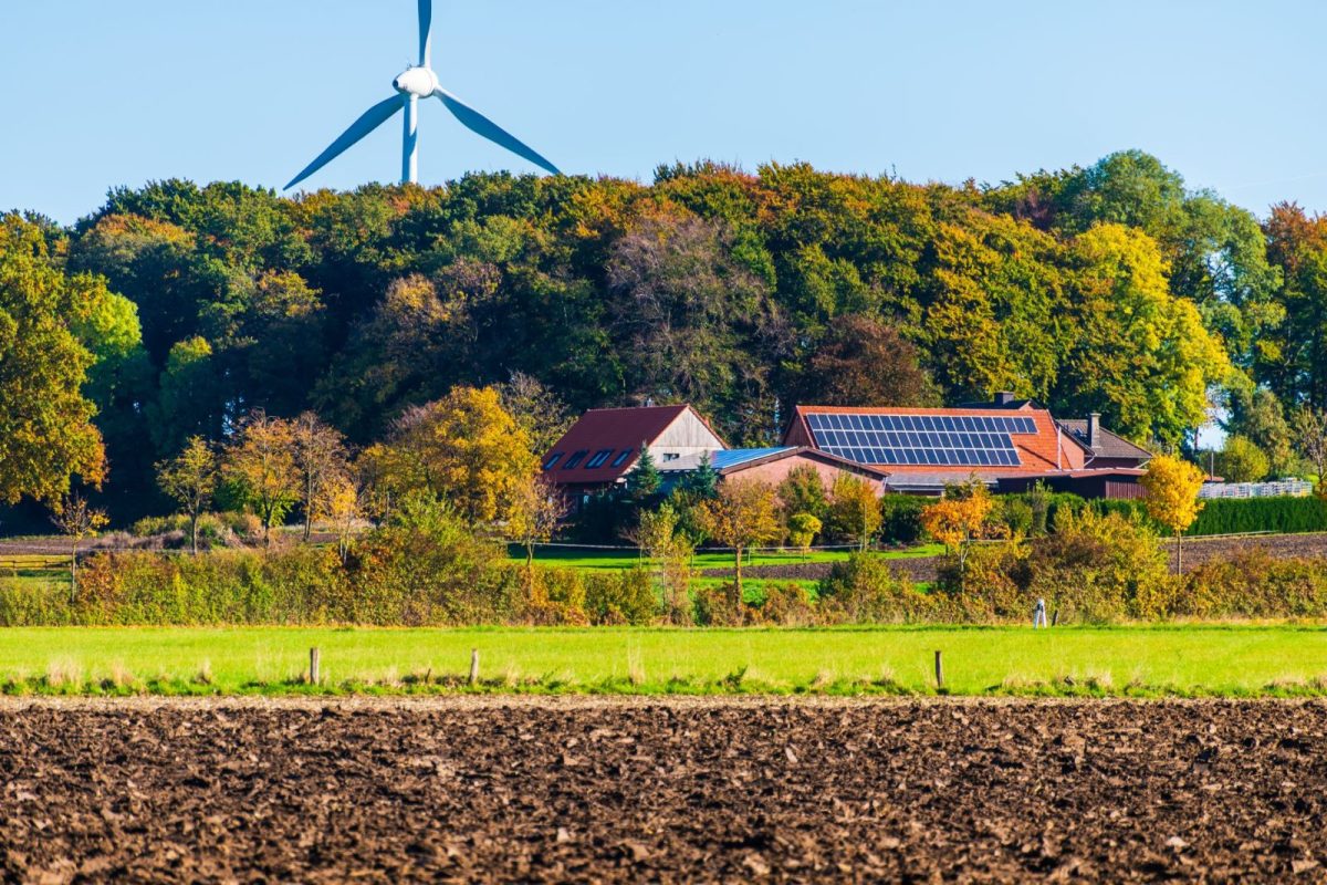 Ground-mounted solar array powering a water pump beside an agricultural field