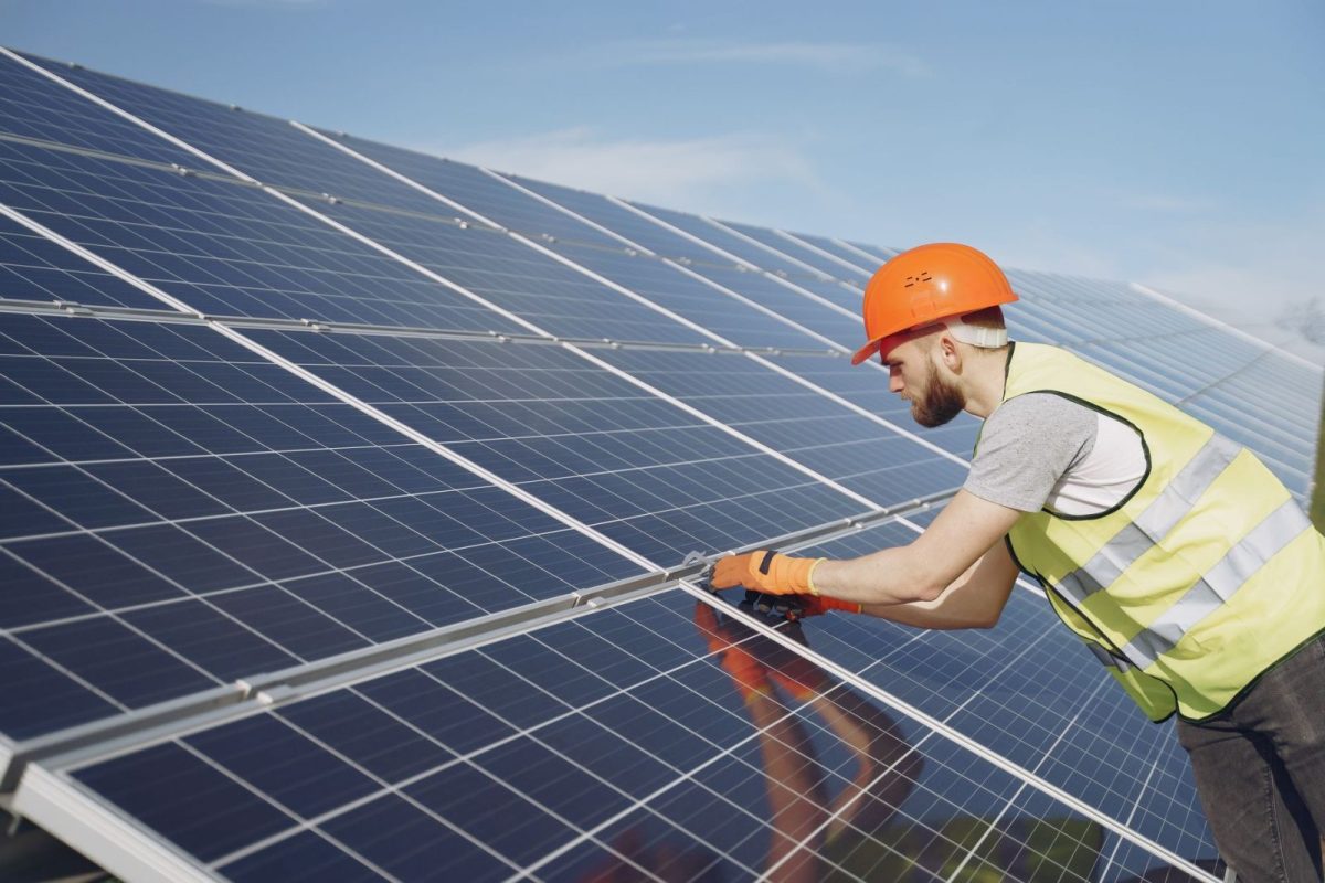 Solar technician inspecting rooftop panels during a service visit