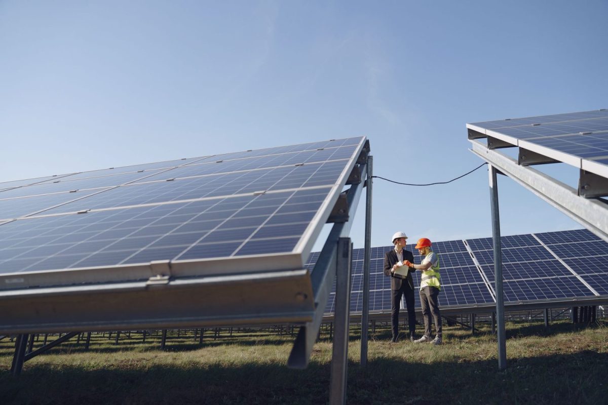 Technician clearing dust from a solar inverter cooling vent during maintenance