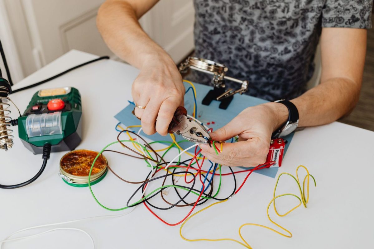 Electrician checking wiring at a home electrical panel with a clamp meter