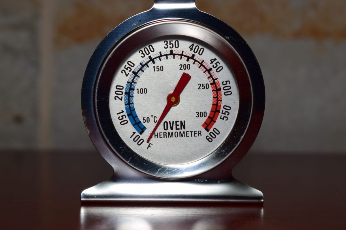 Outdoor thermometer reading a high summer temperature near a solar installation