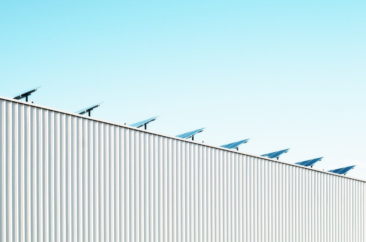 Rooftop solar array with a nearby tree casting partial shade across some panels